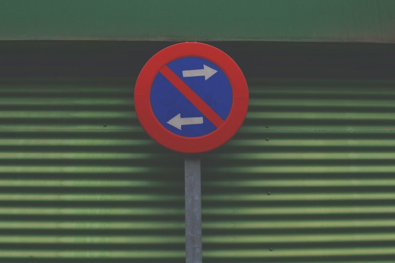 Photo d'un panneau présentant deux flèches allant dans des directions opposées. 