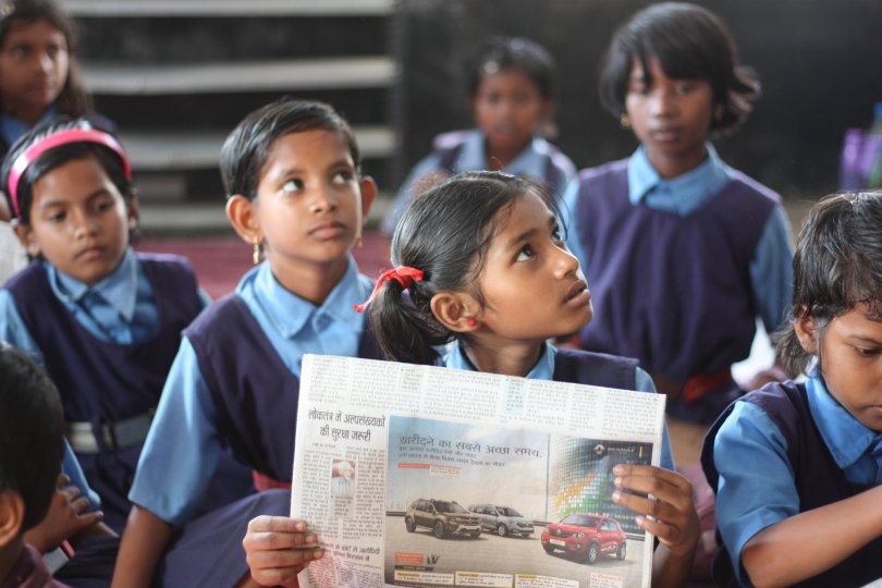 Indian school children holding a poster.