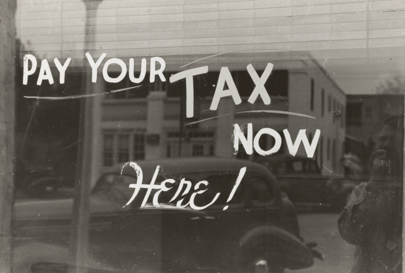 Photo d'une vitrine proclamant : "Pay your tax now here !"