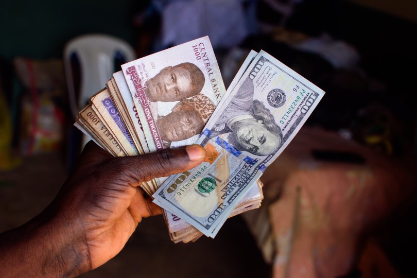 Hand holding several Sub-Saharan African currency banknotes.