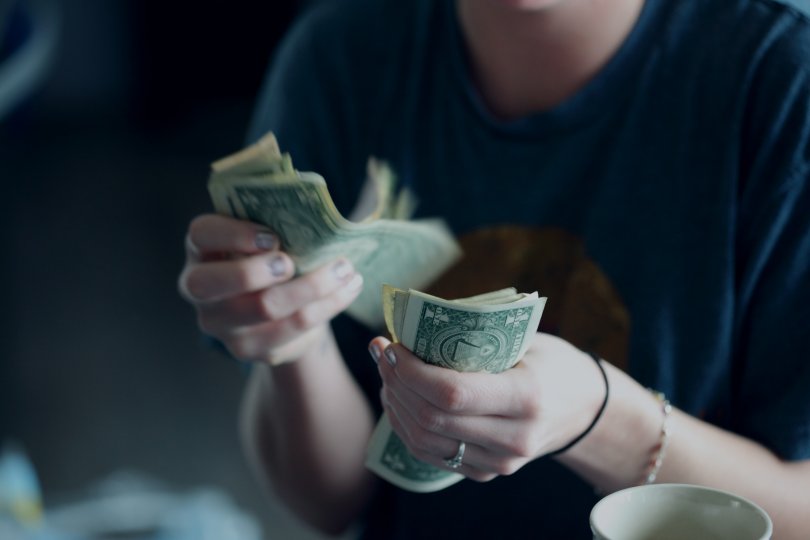 Hands holding and counting a bundle of cash