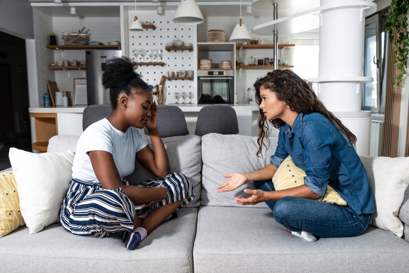 two women talking on a sofa
