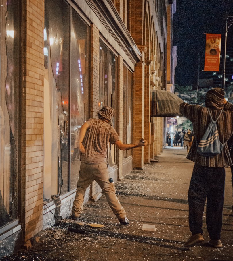 Two men smashing a shop window