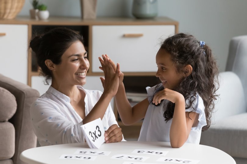A mother and daughter happily complete a homework assignment
