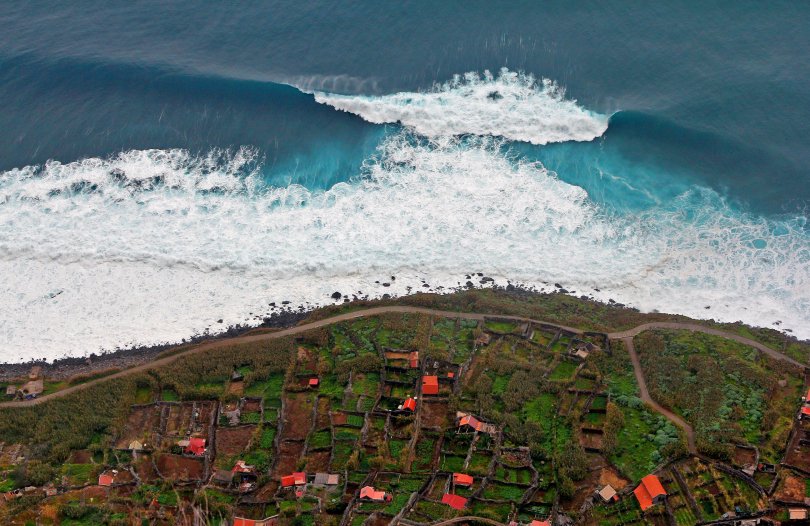 Aerial view of an inhabited coastline battered by waves