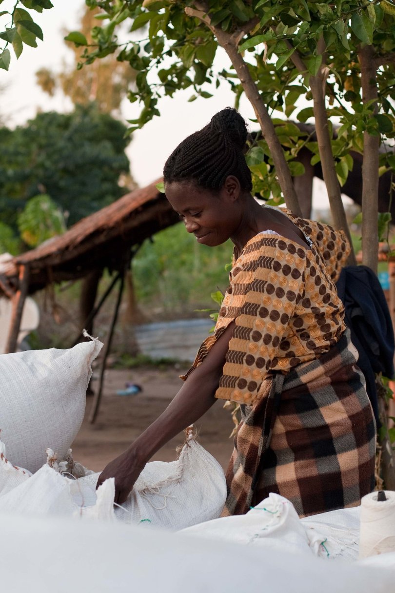 Photo d'une jeune femme Malawi en train de coudre un sac de riz. Photo : Swathi Sridharan via Flickr