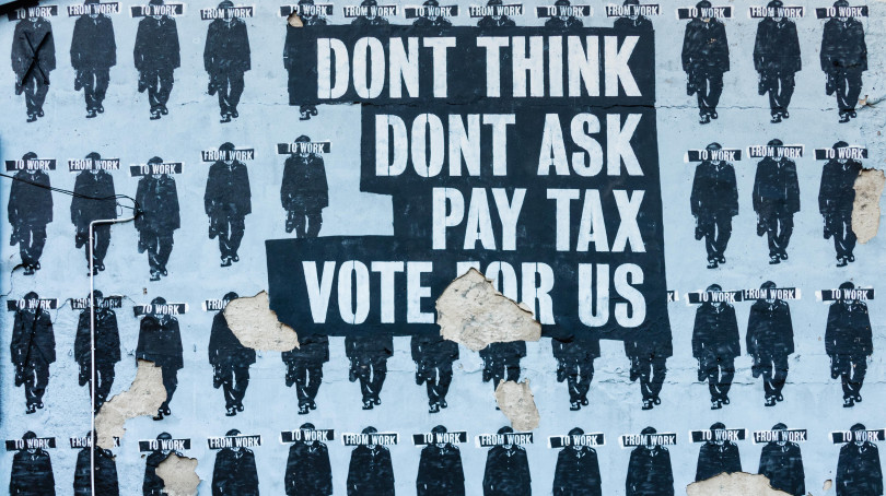 Picture of a poster "Dont' think, don't ask, pay tax, vote for us"