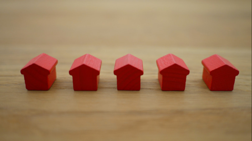 Photo of five monopoly wooden houses