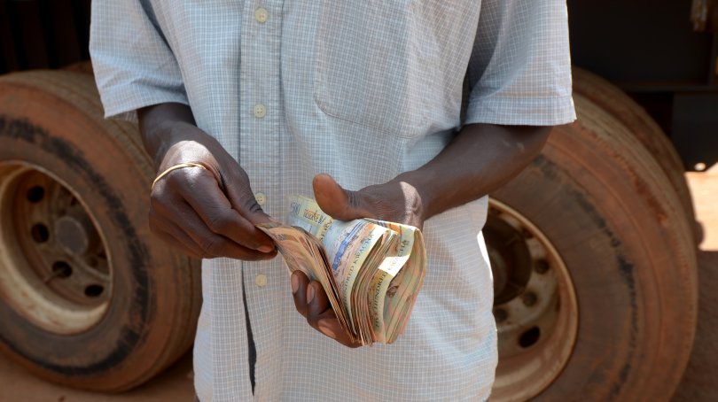 Photo d'un homme tenant des billets dans ses mains. Photo : Africa via AdobeStock
